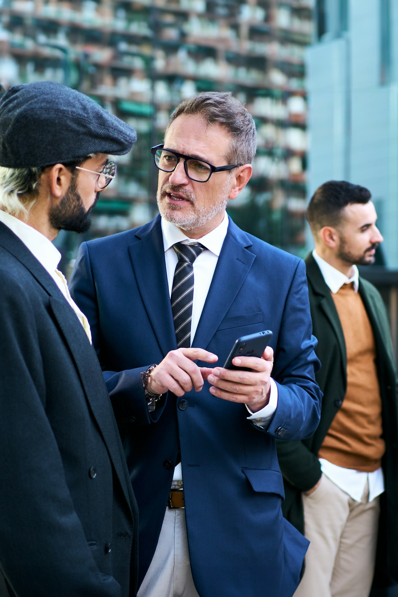 Group Caucasian business men gathered talking serious using mobile phone on break work outdoors.