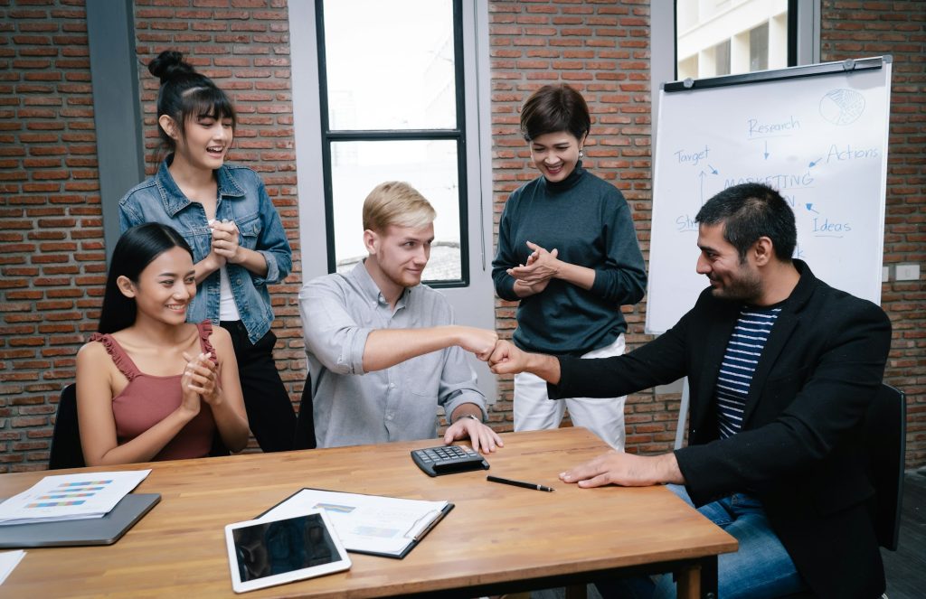 Teamwork of businessman partnership giving fist bump at meeting room in modern office.